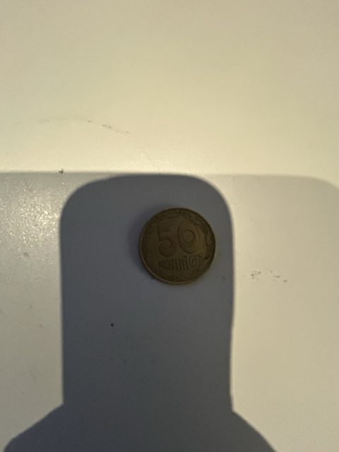 Eine Münze, wie sie auf dem Tisch liegt, vor jeder Verarbeitung fotografiert